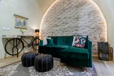 a living room with a green couch and a brick wall at Old Town Square Apartments by Michal&Friends in Prague