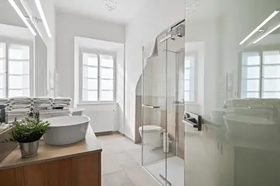 a white bathroom with two sinks and a shower at Old Town Square Apartments by Michal&Friends in Prague