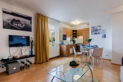 a living room with a dining table and a kitchen at Prague 1 SUNNY APT with terrace by Michal&Friends in Prague