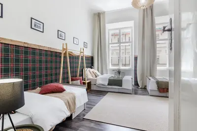 a bedroom with two beds and a chair and a window at Historic Centre Prague Apartments by Michal&Friends in Prague