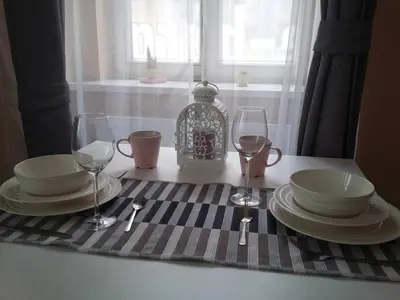 a table with plates and wine glasses on a table at NOT POSSIBLE TO BOOK Apartment Vltavska F in Prague