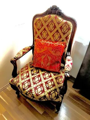 a chair with a pillow on top of it at NOT POSSIBLE TO BOOK Apartment Vltavska F in Prague
