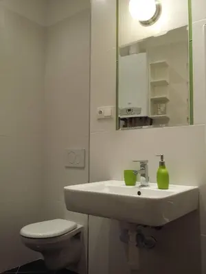 a white bathroom with a sink and a toilet at NOT POSSIBLE TO BOOK Apartment Vltavska F in Prague