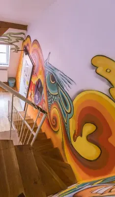 a mural on the wall of a room with stairs at The MadHouse Prague in Prague