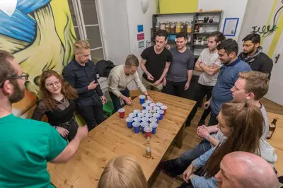 a group of people standing around a table at The MadHouse Prague in Prague