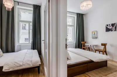 a bedroom with two beds and a table at Zizkov APT Prague by Michal&Friends in Prague