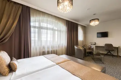 a hotel room with a large bed and a desk at Hotel SEN in Senohraby