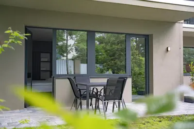 a patio with chairs and a table in front of a house at Penzion Lesni in Milovice