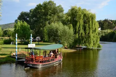 a boat on a river with people on it at Stary dum in Černošice