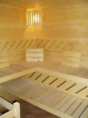 a wooden bed in a wooden cabin with a window at Hotel Kolonie in Křivoklát