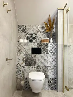 a bathroom with a toilet and a tiled wall at Hotel Lony in Mochov