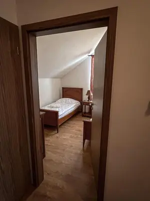 a hallway with a bed in a room at Hotel Lony in Mochov