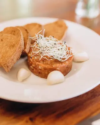 a plate with two donuts and bread on a table at Hotel Lony in Mochov
