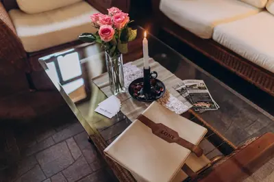 a glass table with a vase of flowers and a candle at Hotel Lony in Mochov