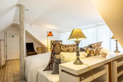 a bedroom with a bed and a table with a lamp at Family Hotel Okoř in Okoř