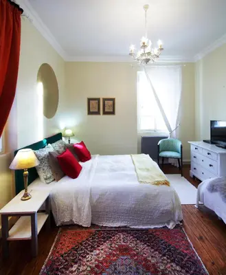 a bedroom with a white bed with red pillows at Family Hotel Okoř in Okoř