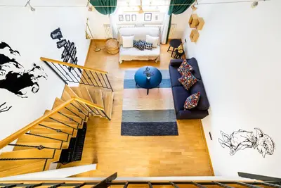 a living room with a staircase and a couch at 4BR 3BATH BALCONY central Harry Potter penthouse in Prague