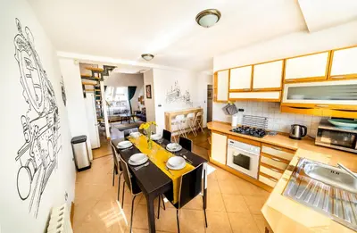 a kitchen with a dining room table with black chairs at 4BR 3BATH BALCONY central Harry Potter penthouse in Prague