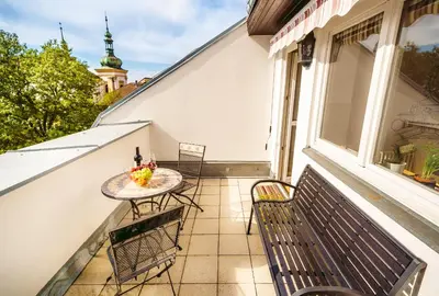 a balcony with a table and chairs and a window at 4BR 3BATH BALCONY central Harry Potter penthouse in Prague