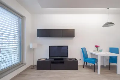 a living room with a tv and a table and chairs at Bright Studio, 10min Centre, Free Parking in Prague