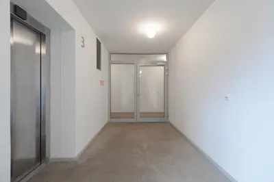 an empty corridor with doors in a building at Bright Studio, 10min Centre, Free Parking in Prague