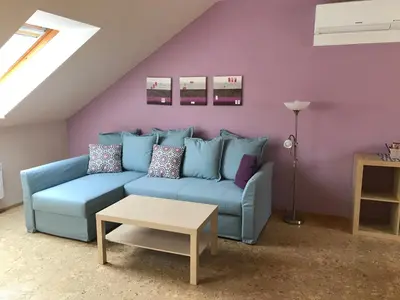 a living room with a blue couch and a table at Apartmany U Stareho Labe in Nymburk