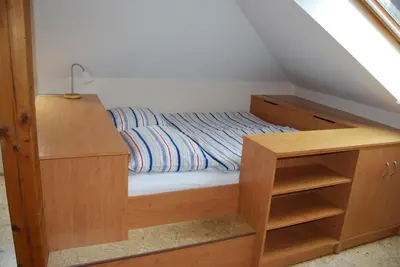 a bedroom with a bed with a wooden desk at Apartmany U Stareho Labe in Nymburk