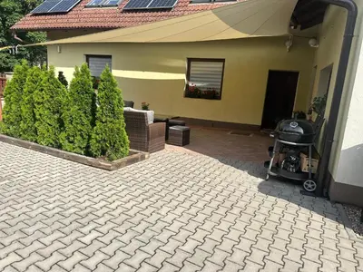 a house with a patio with a grill and bushes at Apartmany U Stareho Labe in Nymburk