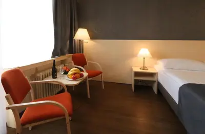 a hotel room with a bed and a table and chairs at Hotel Krystal in Prague