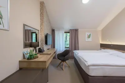 a hotel room with a bed and a desk with a computer at Hotel Panská Zahrada in Dobřichovice