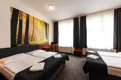 a hotel room with two beds and a large window at Hotel Zlatá Váha in Prague