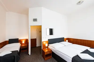 a bedroom with two beds and a hallway at Hotel Zlatá Váha in Prague