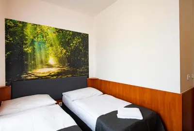 two beds in a room with a painting on the wall at Hotel Zlatá Váha in Prague