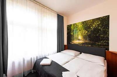 a bedroom with a bed with a painting on the wall at Hotel Zlatá Váha in Prague