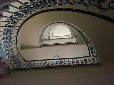 a mirror with a spiral staircase in a room at Hotel Zlatá Váha in Prague