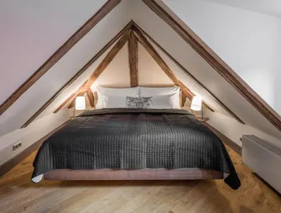 a bedroom with a black bed in a loft at 3 Epoques Apartments by Adrez in Prague