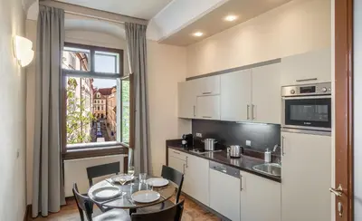 a kitchen with a table and a dining room at 3 Epoques Apartments by Adrez in Prague