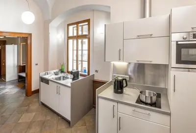 a kitchen with white cabinets and a sink at 3 Epoques Apartments by Adrez in Prague