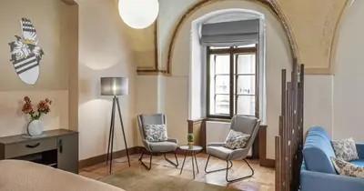 a living room with a blue couch and two chairs at 3 Epoques Apartments by Adrez in Prague
