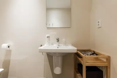 a white bathroom with a sink and a toilet at Prague Days - Sunny Riverside Apartments with Terraces in Prague