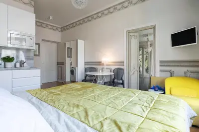 a bedroom with a large bed and a table at Prague Days - Sunny Riverside Apartments with Terraces in Prague