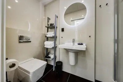 a bathroom with a toilet and a sink and a mirror at Prague Days - Sunny Riverside Apartments with Terraces in Prague