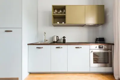 a kitchen with white cabinets and a sink at Prague Days - Sunny Riverside Apartments with Terraces in Prague
