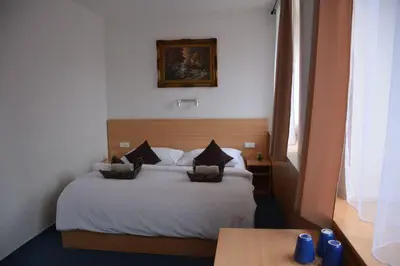a bedroom with a white bed with pillows on it at Hotel O.K. 1 in Beroun