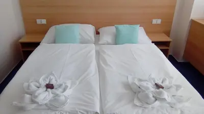 two white sheets on a bed with flowers on them at Hotel O.K. 1 in Beroun
