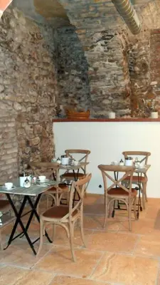 a room with tables and chairs and a stone wall at Jungmann Hotel in Prague