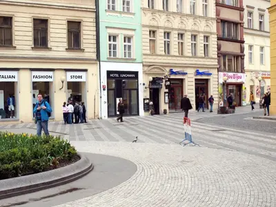 a group of people walking on a street with buildings at Jungmann Hotel in Prague
