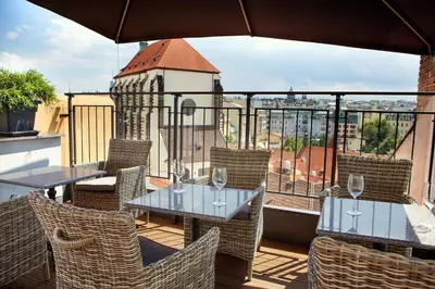 two tables and chairs on a balcony with a view at Jungmann Hotel in Prague
