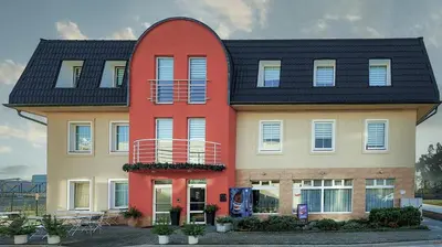 a large house with a red circle on it at Hotel NED HOCKEY in Nymburk