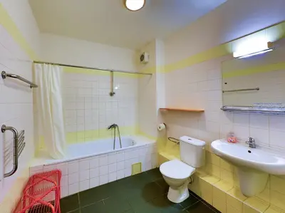 a bathroom with a sink and a toilet and a bath tub at Hotel NED HOCKEY in Nymburk